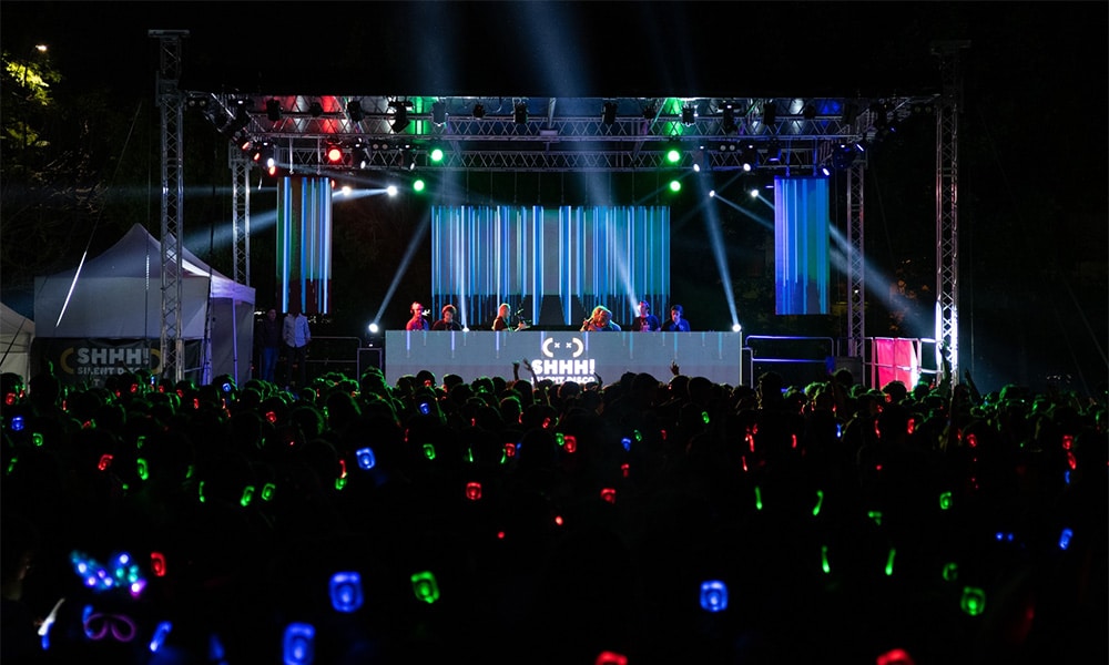 Palco con luci e pubblico in cuffia a un evento aziendale